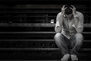 man holds head feeling long term effects of inhalants