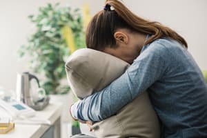 Amphetamine Dependence woman on couch with face in pillow suffering from amphetamine withdrawal and dependance