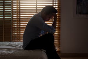 Fioricet Side-Effects Man sitting on bed with head down portraying an individual experiencing Fioricet side effects