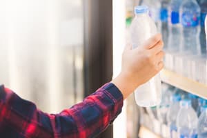 Person grabbing water bottle from grocery store fridge