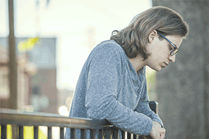 Sad man leaning over balcony