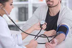 doctor checking blood pressure of patient