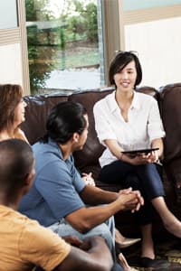woman sits in livingroom talking to friends