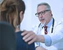 doctor talking to patient with hand on her shoulder